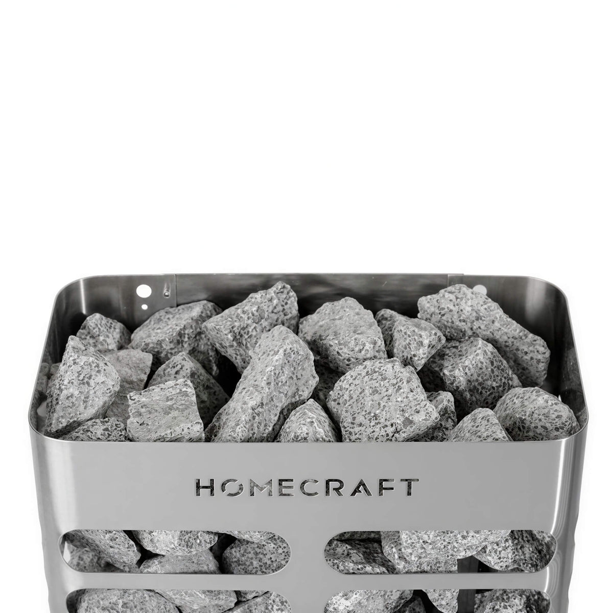 Grey stones inside a rectangular silver metal Homecraft sauna heater with horizontal cutouts.