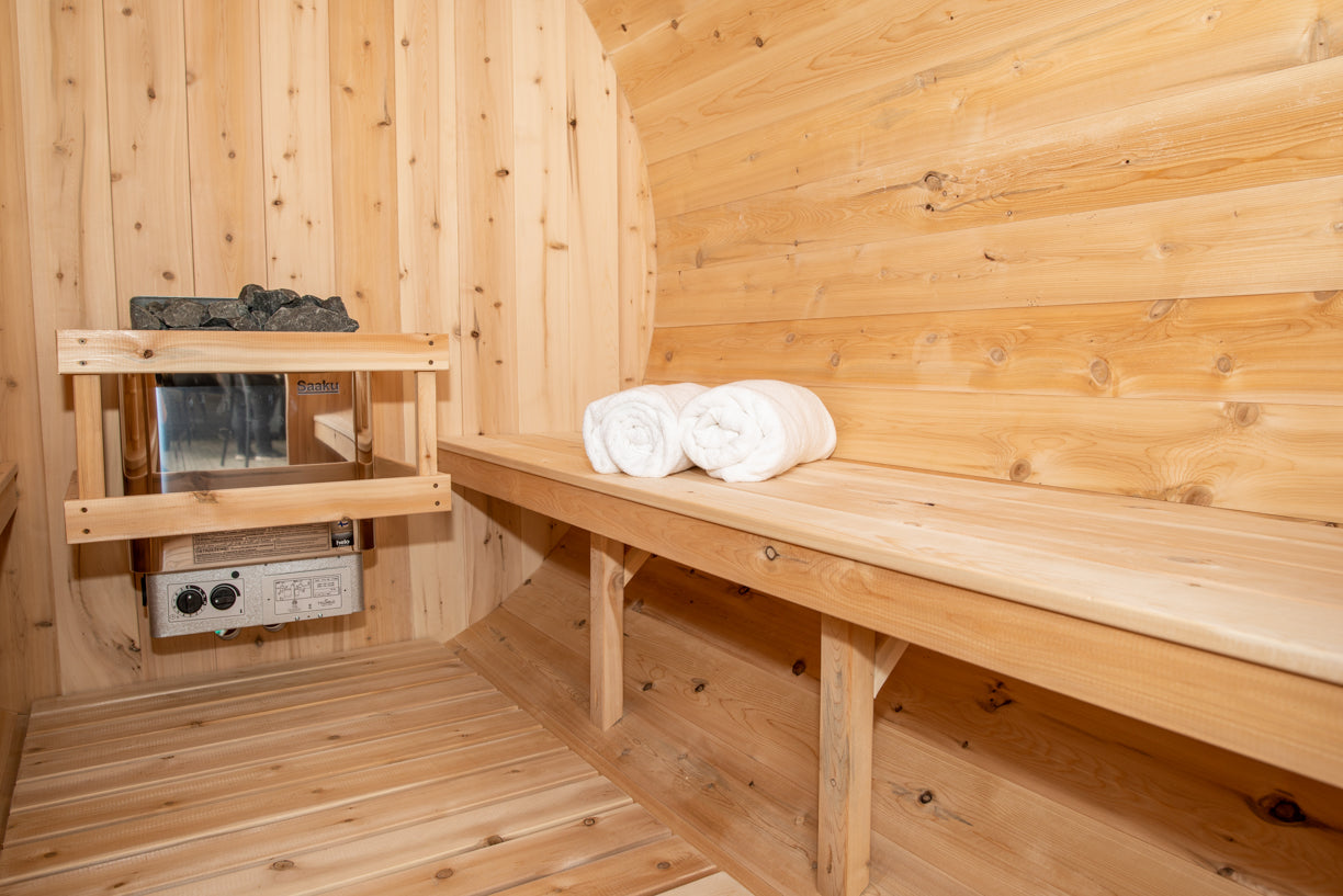 Wooden sauna with a bench, towels, and equipment.