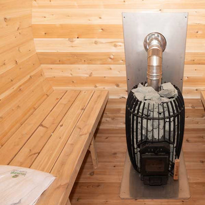 Wood-fired stove in a wooden sauna with a bench.
