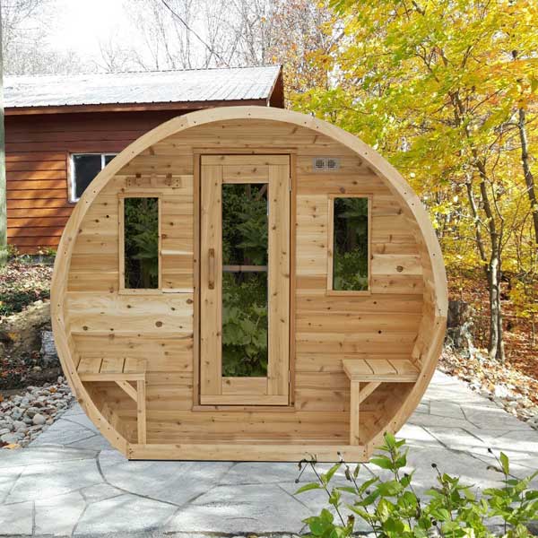 Wooden barrel-shaped structure with windows in a natural setting