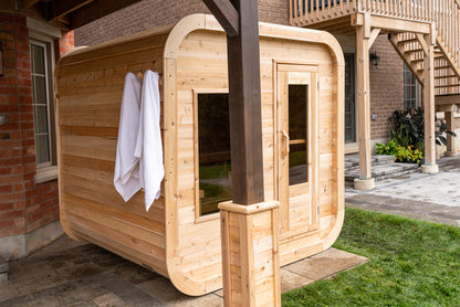 Wooden outdoor sauna with a towel hanging on a brick building