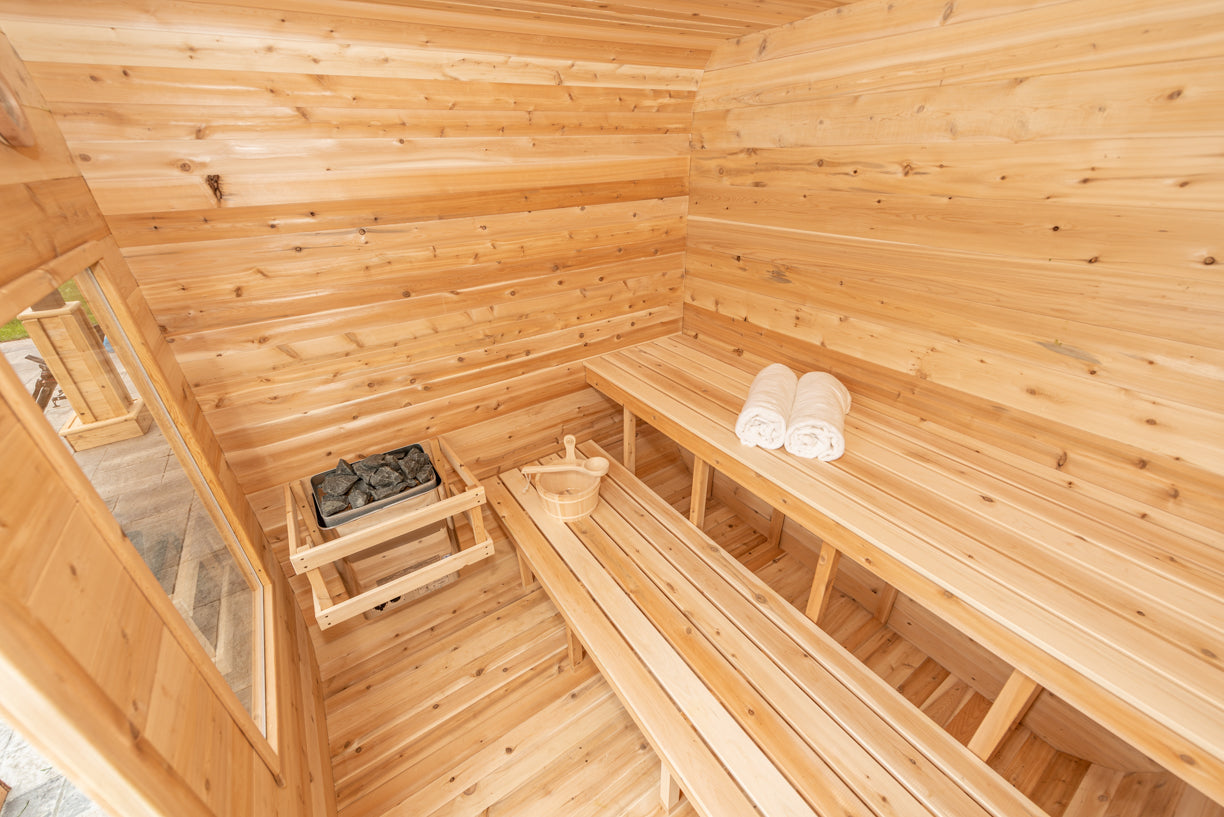 Wooden sauna interior with benches and towels.