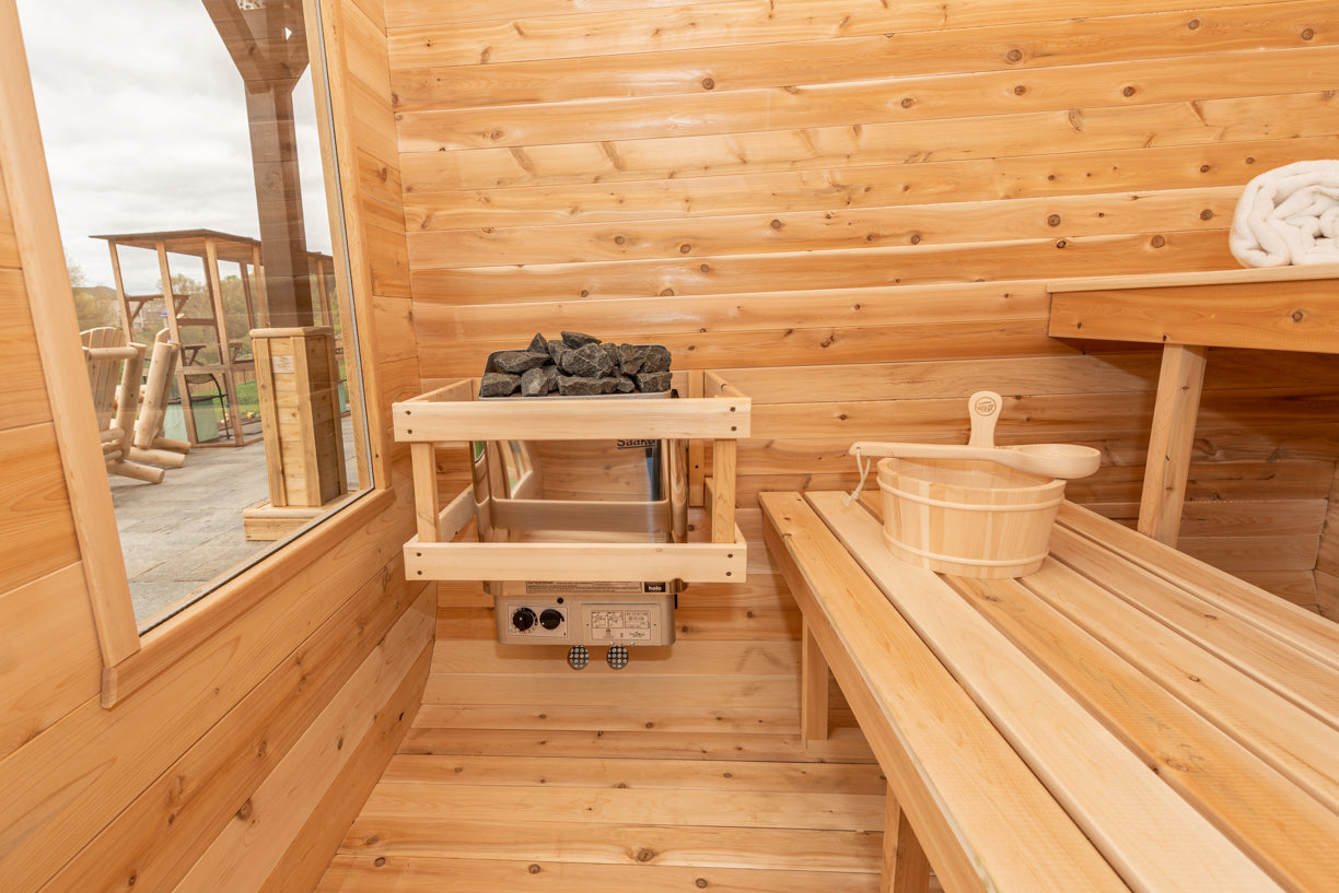 Wooden sauna interior with bench, bucket, and stone holder.