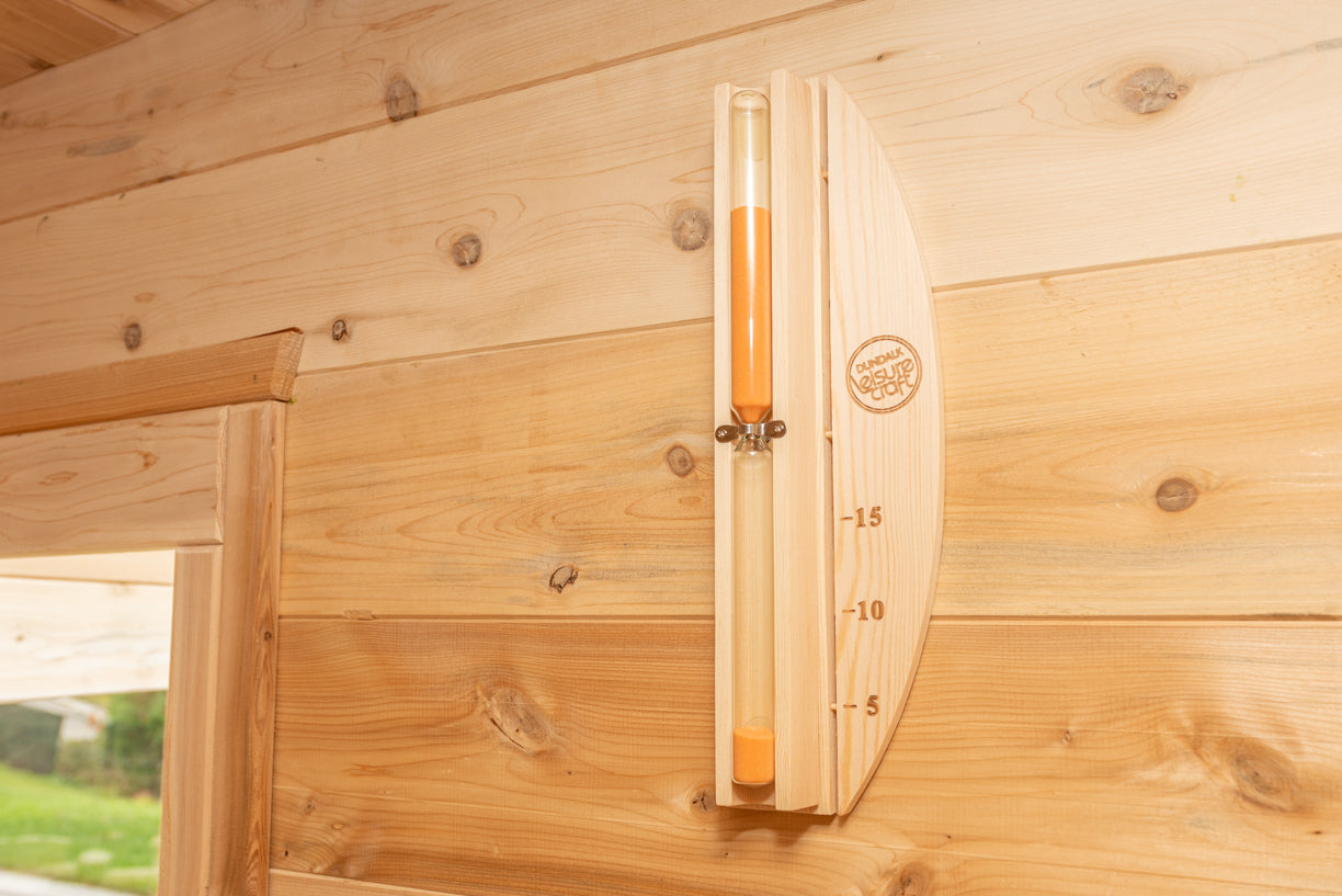 Wooden wall with a temperature gauge attached, showing a brand logo.