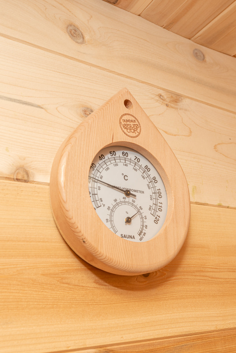Wooden thermometer and hygrometer on a wooden wall
