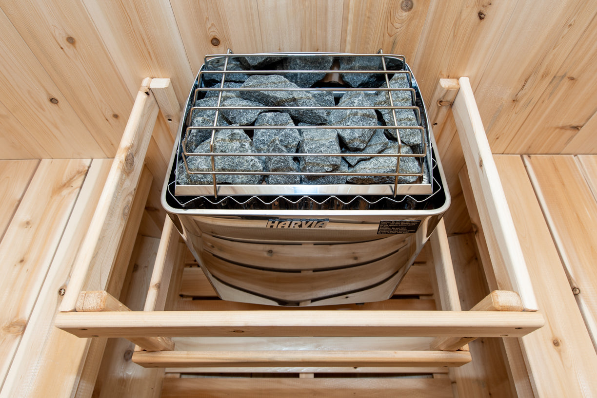 Stone-lined sauna heater with wooden frame inside a wooden sauna room