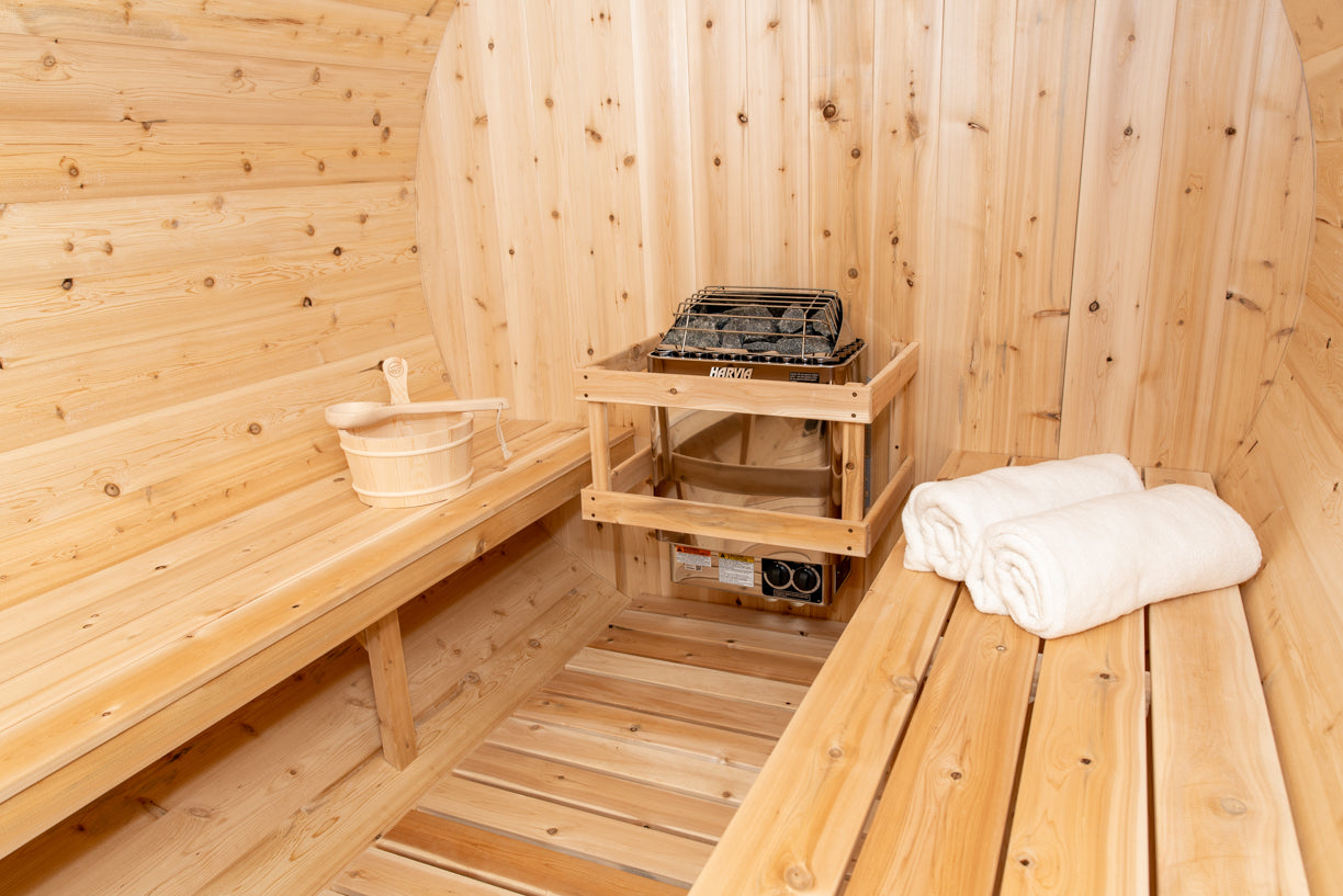 Wooden sauna interior with a bench, towel, and small table.