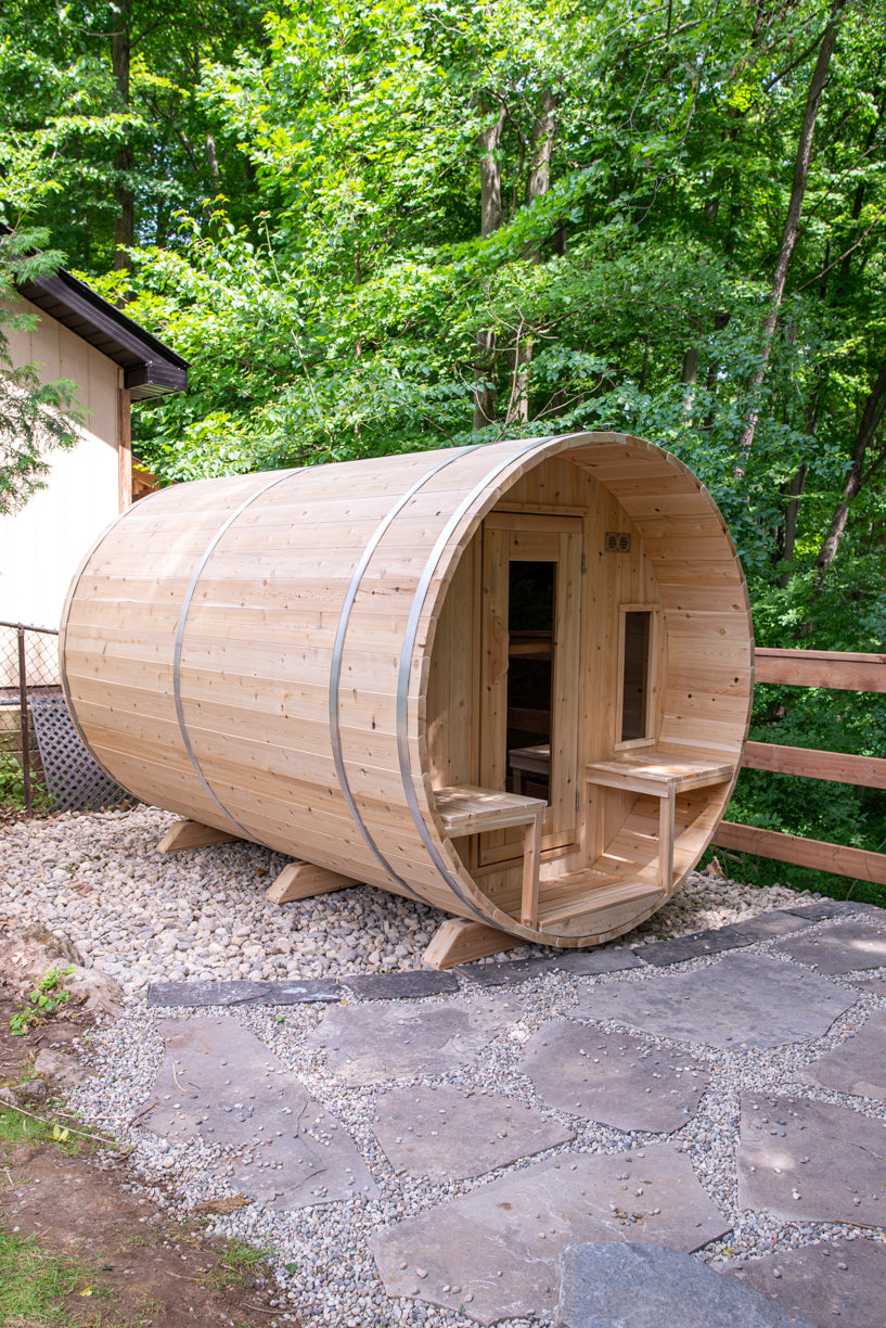 Wooden barrel-shaped sauna in a forest setting