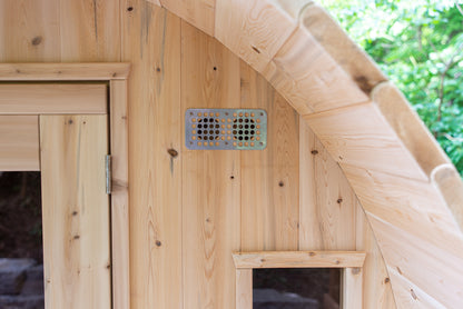 Close up of air vent on front of wooden barrel sauna and window