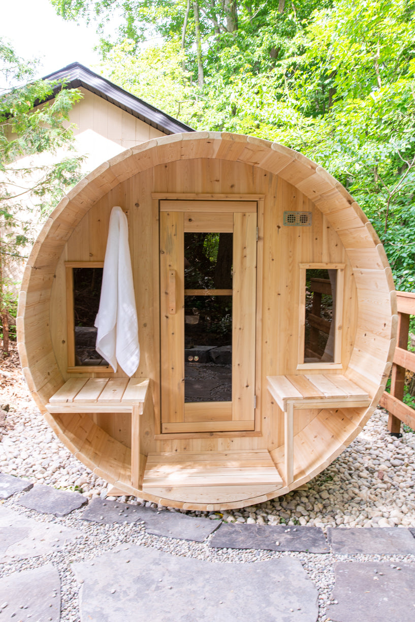Wooden barrel-shaped sauna in a forest setting