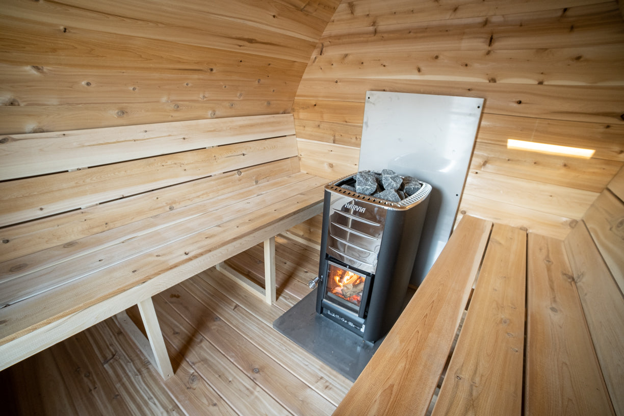 Wooden sauna interior with a stove and benches.