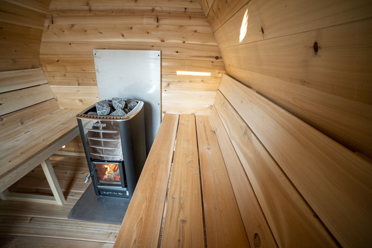 Wooden sauna interior with a stove and benches.
