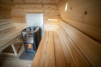 Wooden sauna interior with a stove and benches.