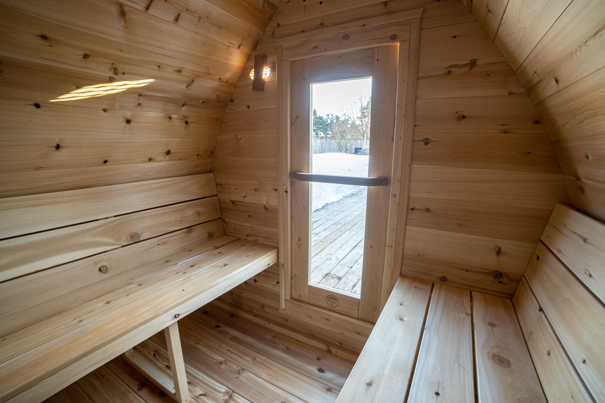 Wooden sauna interior with a door open to the outdoors