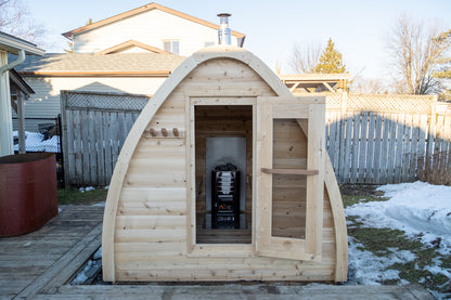 CT MiniPOD Woodburning Sauna by Leisurecraft with door open, set against a residential backyard with snow on the ground.