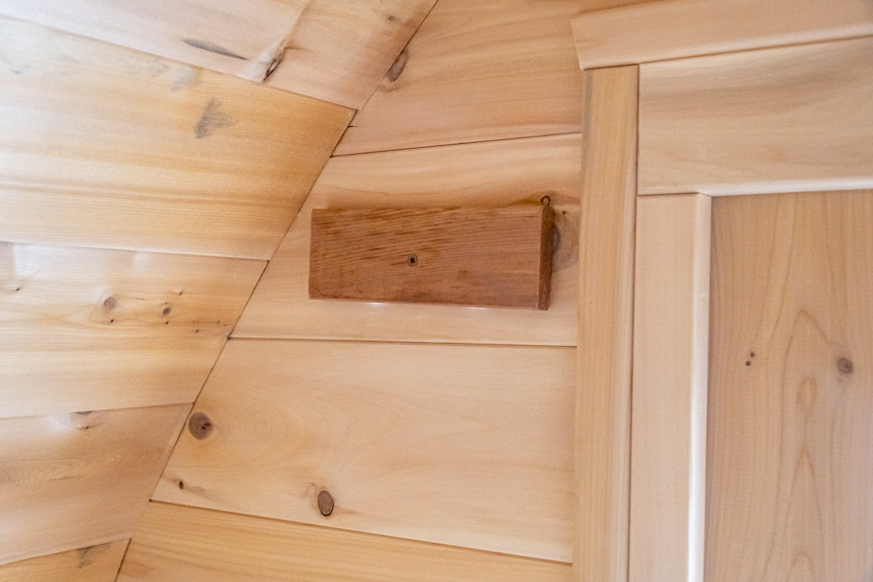 Wooden interior wall of sauna showing wood block for vent flow. 
