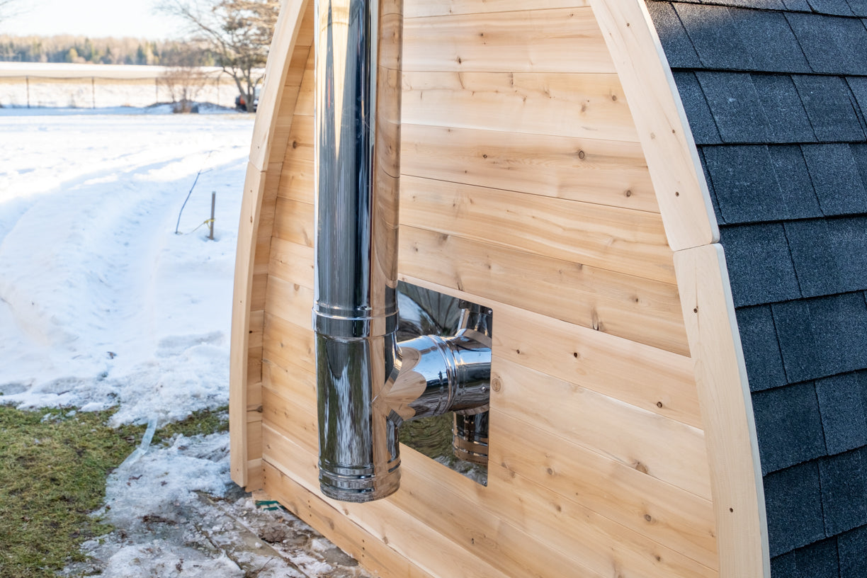 CT MiniPOD Woodburning Sauna by Leisurecraft metal exhaust pipe as it comes out of the back of the sauna in a snowy landscape