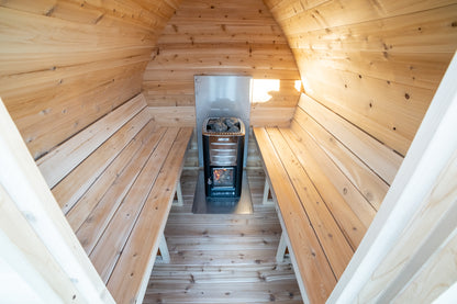 Wooden sauna interior with benches and a stove.