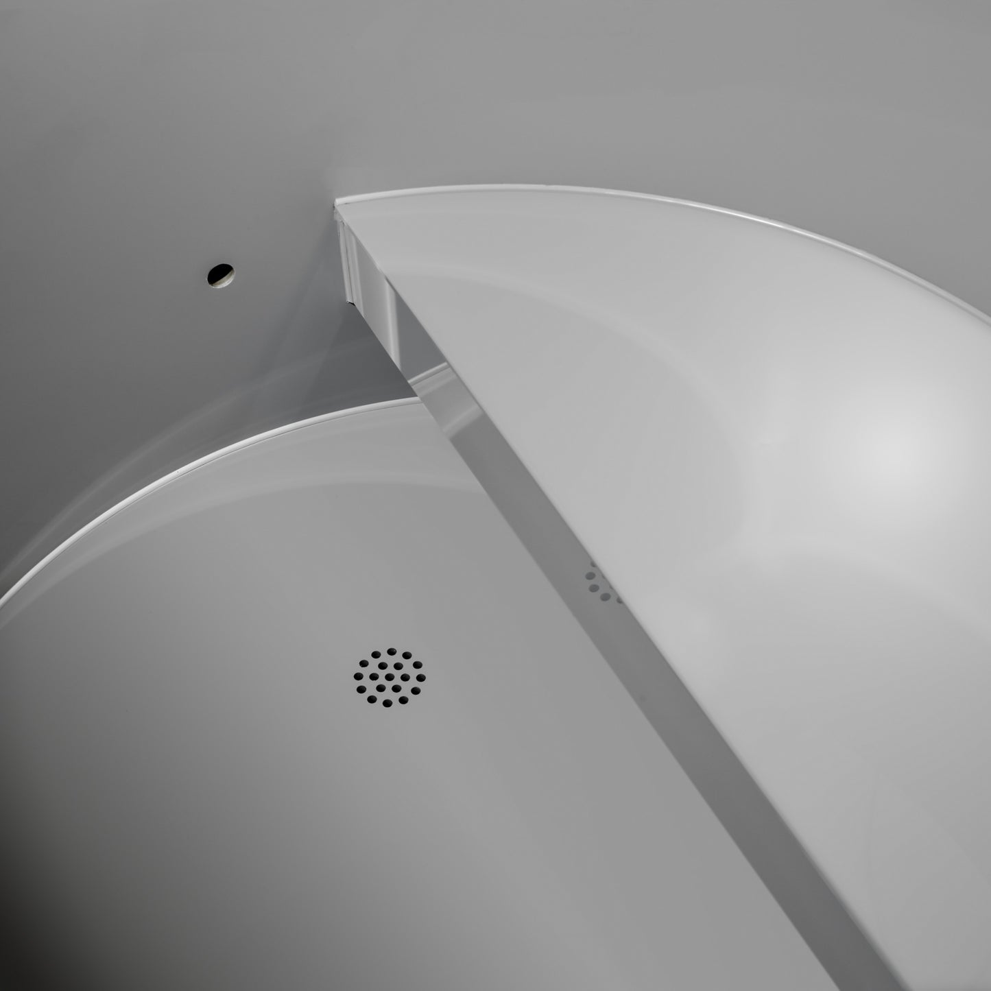 Close-up of inside the Dynamic Cold Therapy DCT-B-042-PLPC-34 Cold Plunge Tub showing the grey plastic color of the seat and floor drain