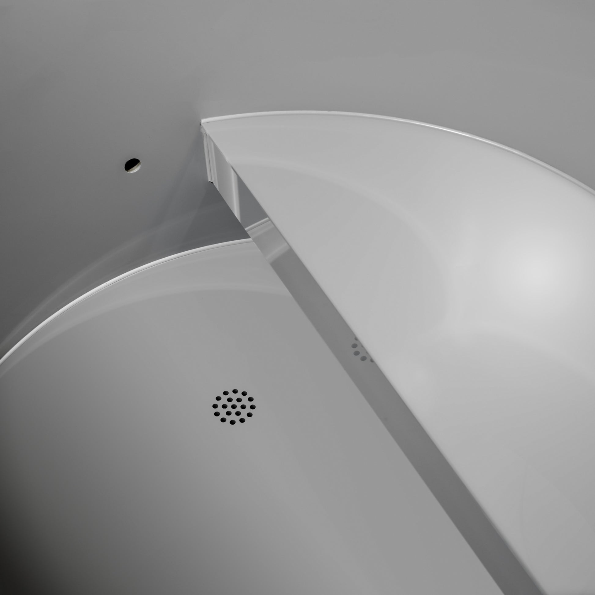 Close-up of inside the Dynamic Cold Therapy DCT-B-042-PLPC-34 Cold Plunge Tub showing the grey plastic color of the seat and floor drain