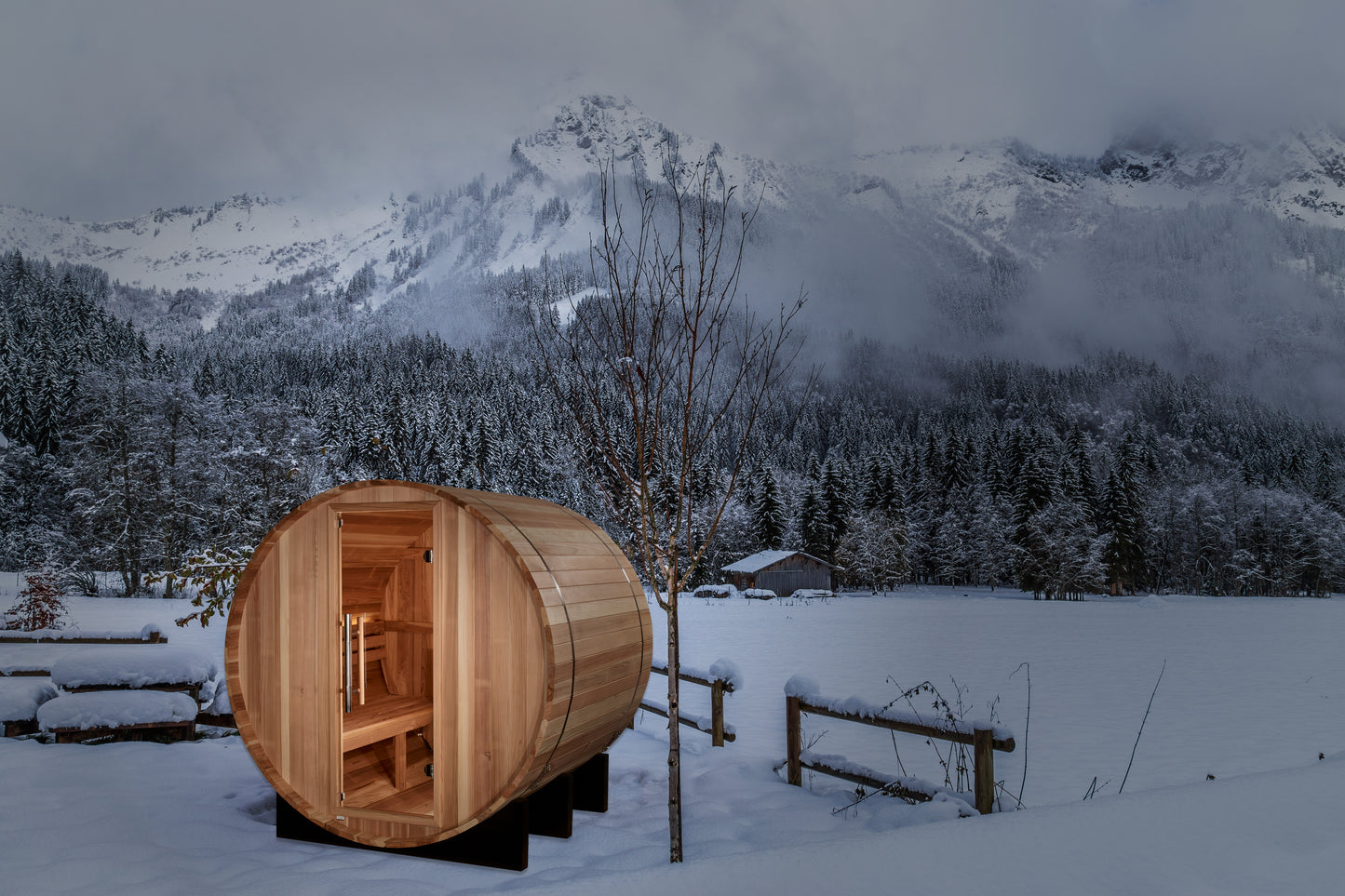 Golden Designs "St. Moritz" 2 Person Barrel Traditional Sauna pictured in a snow covered yard with mountains in the background
