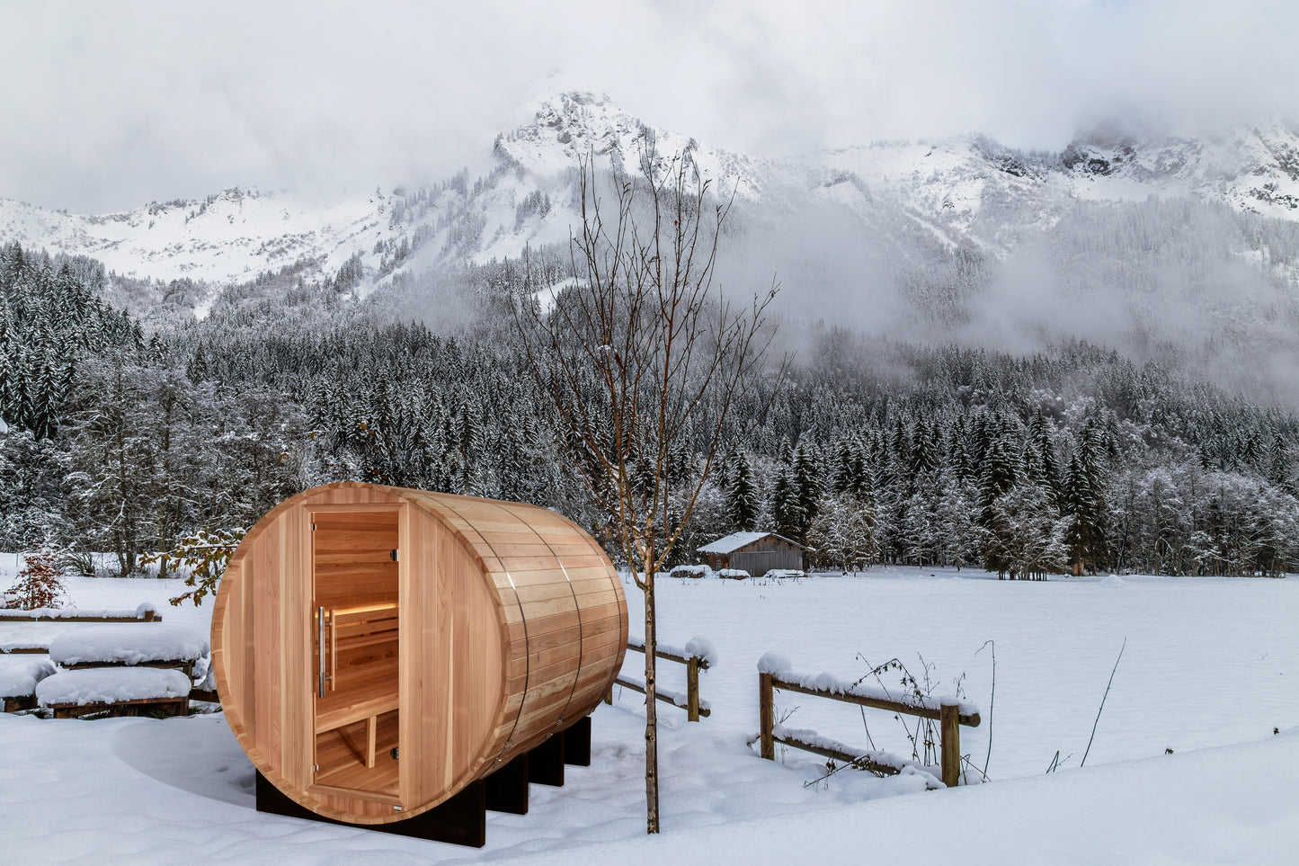 Golden Designs Klosters 6 person traditional sauna pictured in the snow with snow covered mountains in the background