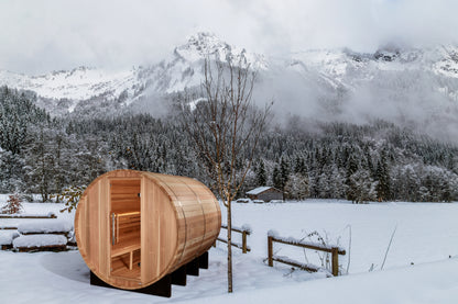 Golden Designs Klosters 6 person traditional sauna pictured in the snow with snow covered mountains in the background
