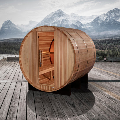 Golden Designs "Zurich" 4 Person Barrel sauna pictured on a deck with rugged mountains in the background