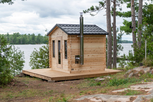 Wooden cabin on a platform by a lake with trees in the background