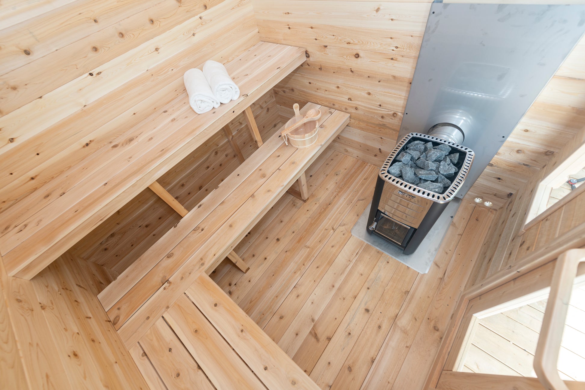 Wooden sauna interior with a stove and benches.