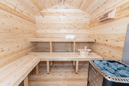 Wooden sauna interior with benches, table, and sauna stones.