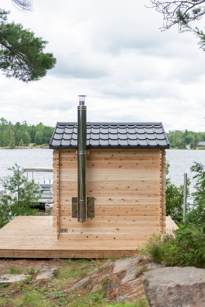 Wooden cabin with a chimney near a body of water