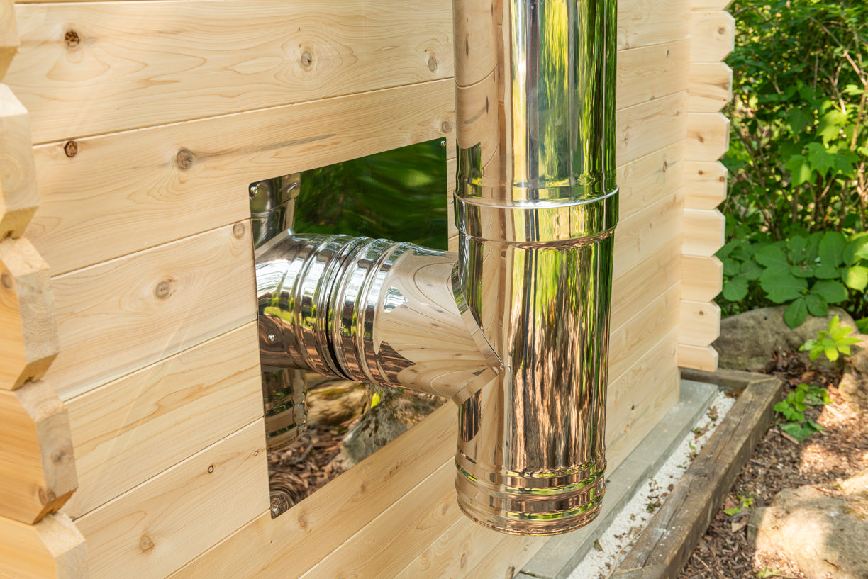 Metal ductwork inside a wooden structure with greenery in the background