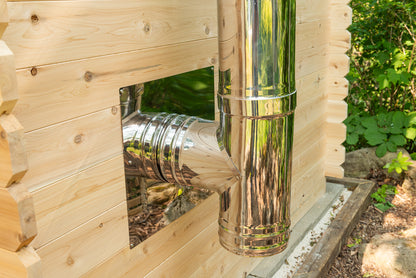 Metal ductwork inside a wooden structure with greenery in the background