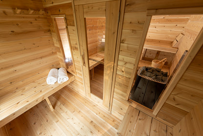 Wooden interior of a sauna with benches and towels.