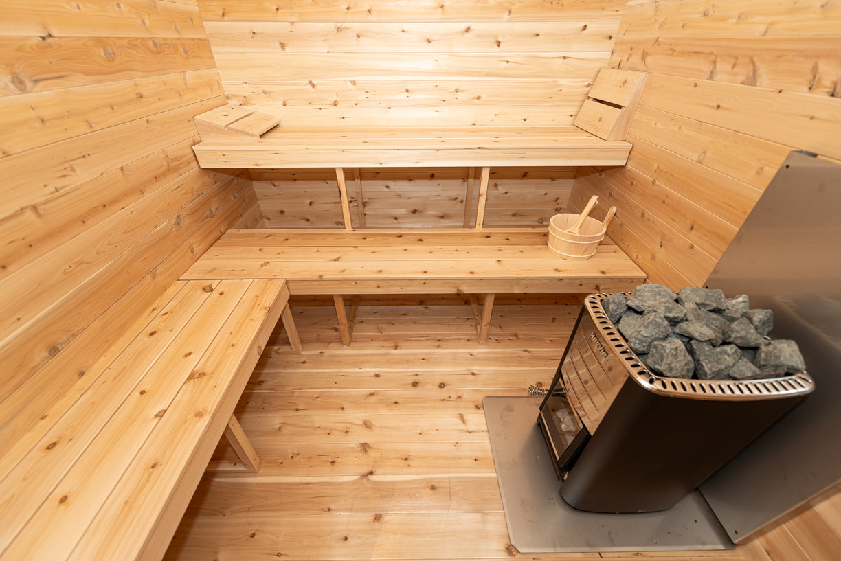 Wooden sauna interior with benches and a stove.