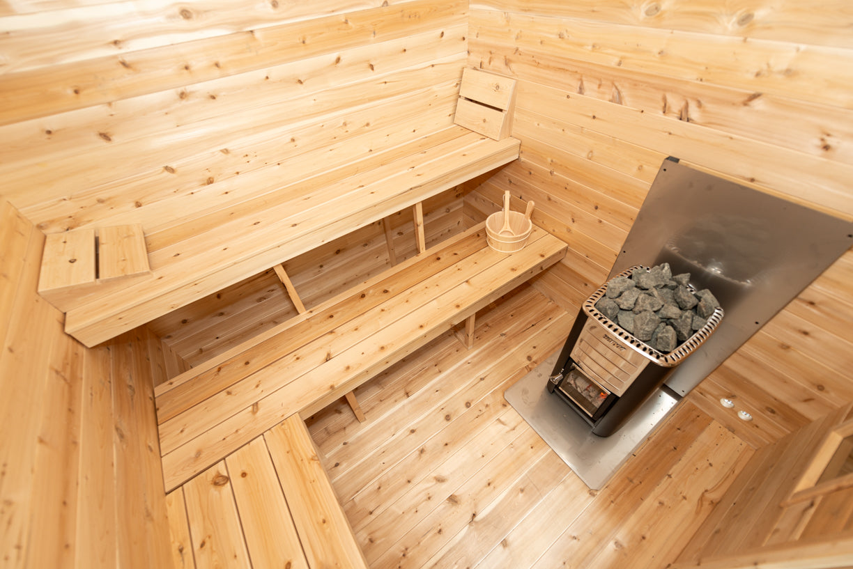 Wooden sauna interior with benches and a fire basket.