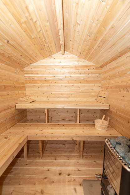 Wooden sauna interior with benches and a basket.
