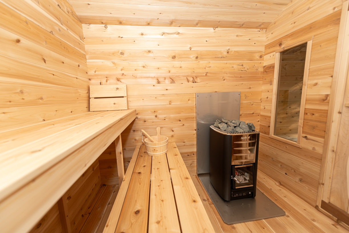 Wooden sauna interior with benches and a heater.