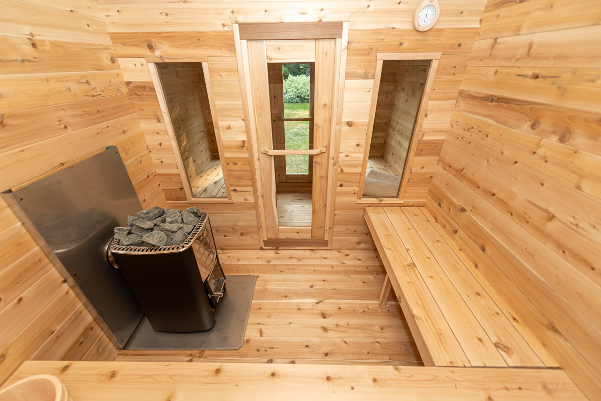 Wooden sauna interior with a bench, mirror, and door.