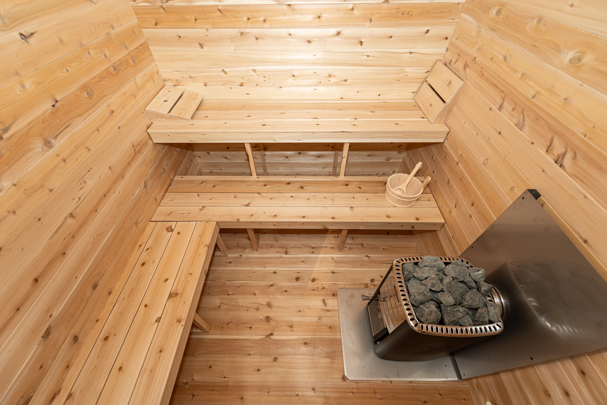 Wooden sauna interior with benches and a stove.
