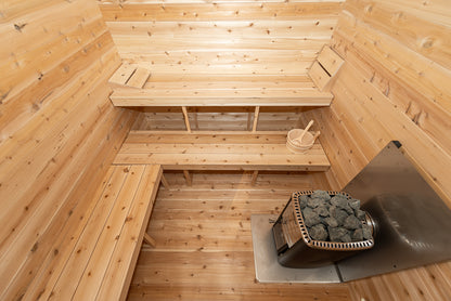 Wooden sauna interior with benches and a stove.