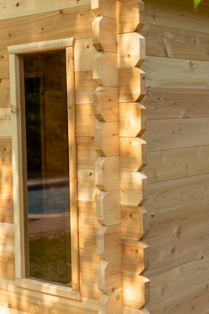 Wooden cabin with a window, showing detailed logs and natural wood texture.