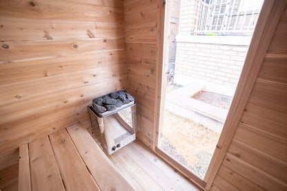 Wooden sauna interior with a window and stone electric heater.