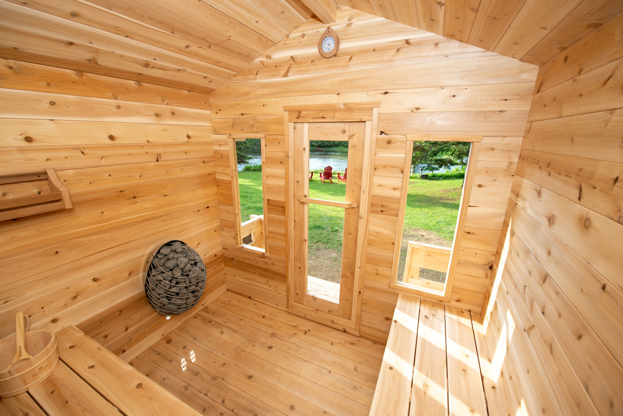Wooden sauna cabin interior with a view of a grassy area outside.