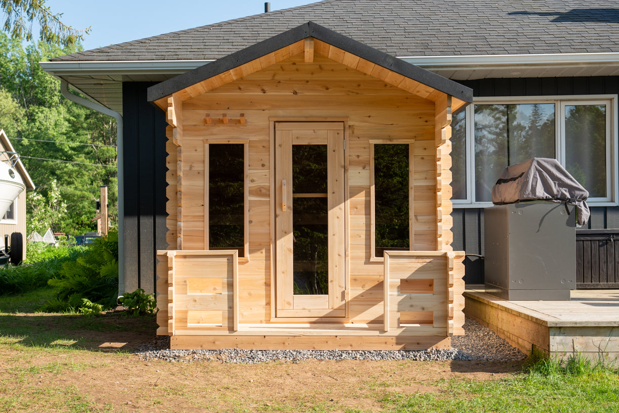 Wooden shed attached to a house with a clear sky background