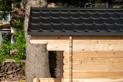 Wooden structure with a black tiled roof in an outdoor setting