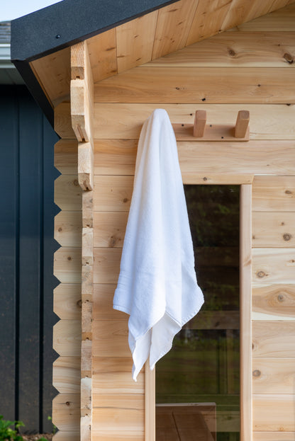 White towel hanging on a wooden sauna.