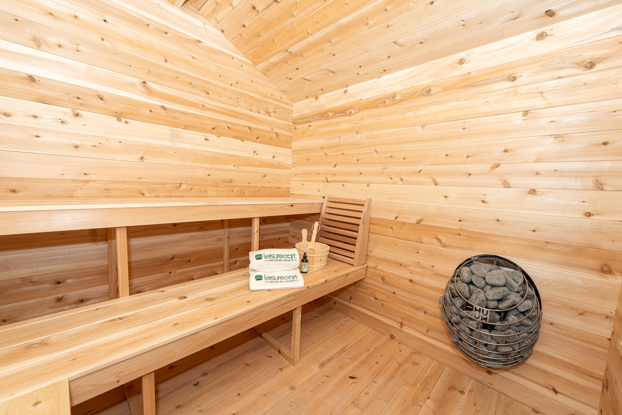 Wooden sauna interior with benches and a basket.