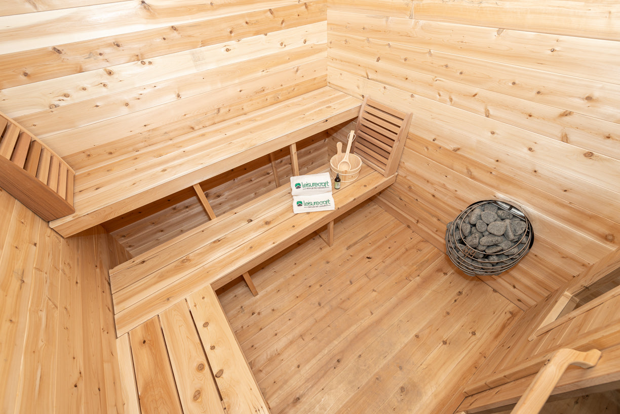 Wooden sauna interior with benches and a basket.